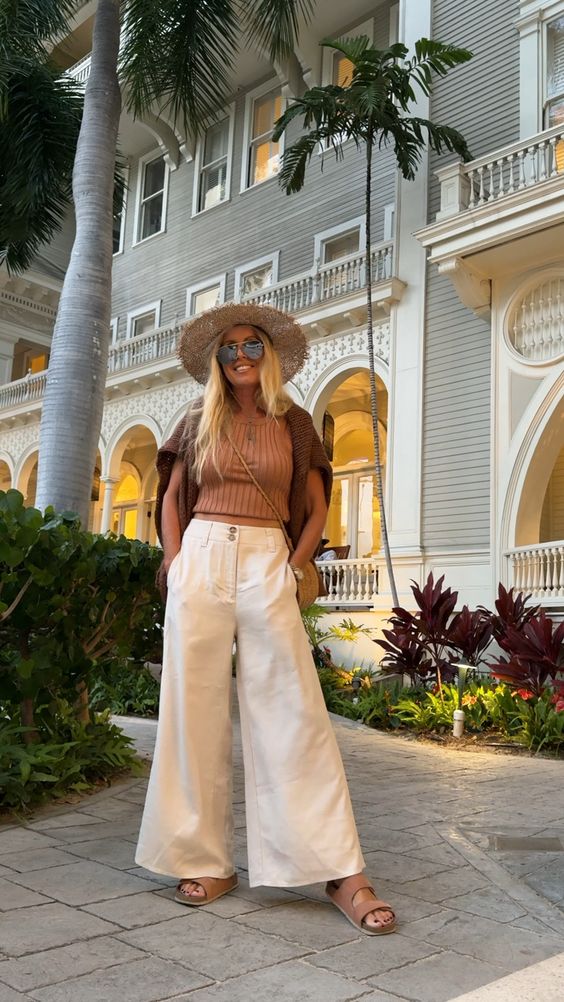 brown tank top paired with white wide-leg pants and Brown sandals